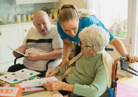 Senior care volunteer helping elderly person