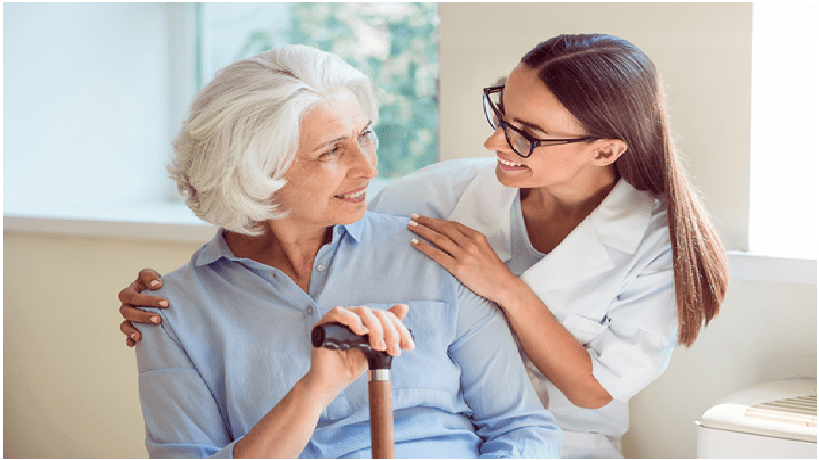 Caregiver and senior woman smiling together in a bright home in The Woodlands Texas