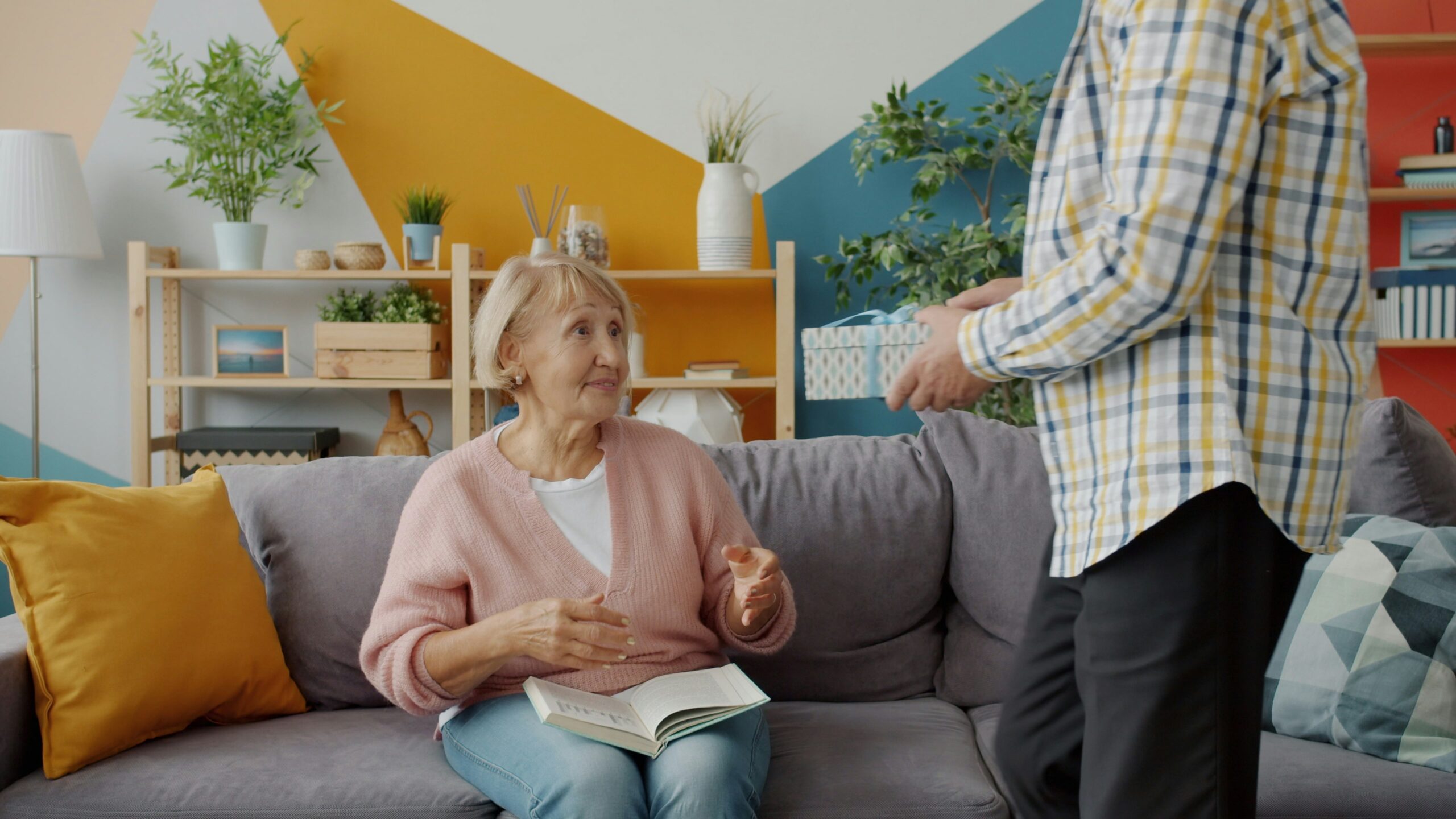 Caregiver and elderly woman with dementia sitting together comfortably at home
